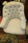 A 20th Century tub chair in oatmeal button back upholstery and turned front legs together with a