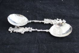 Two silver fruit spoons with shaped bowls and handles decorated with figures in Medieval dress