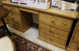 A modern pine dressing table of six assorted drawers to plinth base
