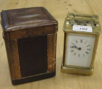 A circa 1900 French lacquered glass cased carriage clock with visible escapement,
