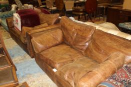 A pair of brown leather two seat sofas