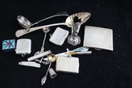 A collection of small silver wares to include a fruit spoon, taper vase, two vesta cases, card case,