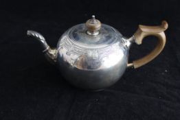 A George V silver squashed bulled shaped teapot with Gothic style engraved decoration and acanthus