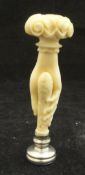 A Victorian hard stone seal with ivory handle carved as a woman's hand holding the seal