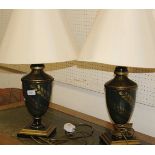 A pair of modern lamps in a dark green ground with gilt leaf decoration,