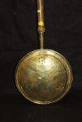 A late 17th/early 18th Century brass bed warming pan with pierced and engraved cover and turned