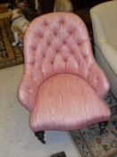 A Victorian Salon chair in a pink button back upholstery stood upon mahogany turned and carved
