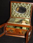 A walnut jewellery box with lift top compartment opening to reveal a green silk fitted interior and