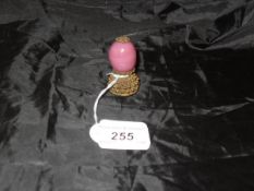 A Chinese mandarin hat finial with brass filigree work and pink glass bead of egg form to simulate
