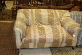 A two seat sofa in a cream and brown striped upholstery by Stephen Perkins on square section