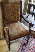 A 19th Century carved oak armchair with upholstered seat and back and carved rams head finials to