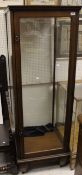 An Edwardian mahogany shop display cabinet with glass sides and single door on square tapered legs