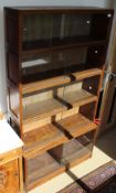 A mahogany five sectional bookcase with sliding glass doors to plinth base,