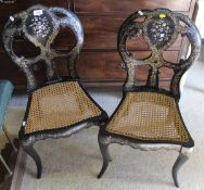 A pair of Victorian ebonised mother of pearl inlaid bedroom chairs with cane seats