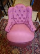 A pink upholstered button back bedroom chair,