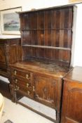 A 20th Century oak dresser with two shelves above a base of three drawers and single cupboard door,