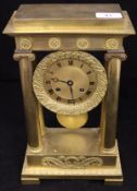 A French Regency period lacquered brass cased mantle clock with Ionic column supports,