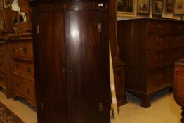 A 19th Century mahogany bow fronted two door wall hanging corner cupboard with satinwood banding to