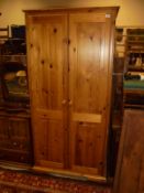 A 20th Century pitch pine two door wardrobe,