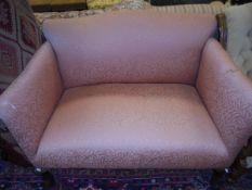 A late 19th / early 20th Century mahogany framed two seat sofa in peach ground leaf patterned