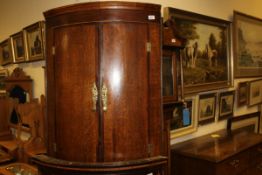 A 19th Century oak and mahogany banded bow front wall hanging corner cupboard of two doors