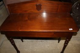 A mahogany side table with raised back and shield motif on turned and ringed legs