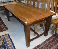 A modern teak table raised on block legs