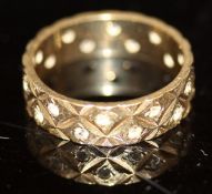 A 9 carat gold band with tooled decoration set with small clear stones, 3.