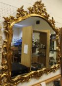 A modern wall mirror with gilt C scroll and foliate decorated frame