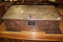 An 18th Century oak bible box with carved decoration to the front panel