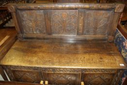 A 19th Century oak bench, the panelled back carved with flowers,