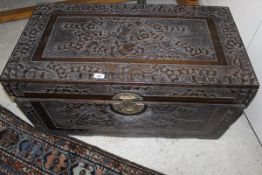 A profusely carved Eastern chest, the top and sides carved with flowering tree,