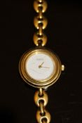 A ladies Gucci watch with yellow metal casing and strap