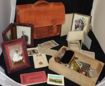 A brown leather satchel, together with a cigarette card album,