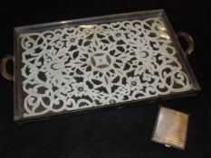 An electro-plated twin-handled tray, the base set with a needlework textile under glass,