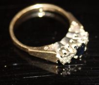 A 9 carat gold ring set with central sapphire flanked by chip diamonds, 3.