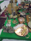 A selection of copper and brassware to include lamp standard, two table lamps, oil lamp,