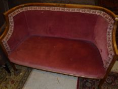 A circa 1900 mahogany framed and satinwood strung two seat sofa in a pink ground upholstery,