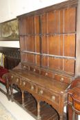 A 19th Century oak dresser with stepped moulded pediment above three shelves and four drawers,