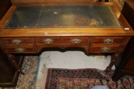 A 19th Century mahogany desk with a blue leather inset top, above a base of five assorted drawers,
