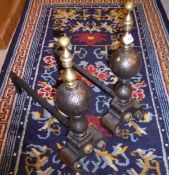 A pair of brass and iron fire dogs in the Gothic Revival taste