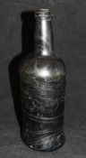 A circa 1800 black glass wine bottle with a swirled pattern and of typical form, 26.