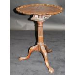 An early 19th Century mahogany tripod table, the plain top with pie crust edge above a birdcage,