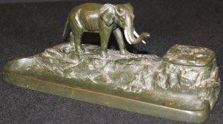 A 19th Century bronze desk stand with pen tray and inkwell, surmounted with a figure of an elephant,