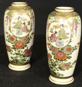 A pair of Japanese Meiji Period Satsuma vases decorated with panels of figures in an interior