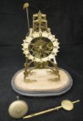 A Victorian brass skeleton clock with Roman numerals to the painted dial