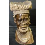 An African hardwood sculpture of a tribal chieftain, the headdress of dished form,
