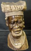 An African hardwood sculpture of a tribal chieftain, the headdress of dished form,