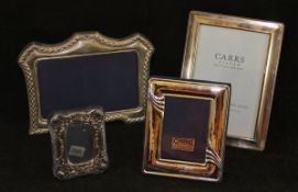 A collection of four various modern silver photograph frames of varying sizes and designs