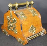 A late Victorian brass and oak coal scuttle with turned brass handle mounted on decorative brass